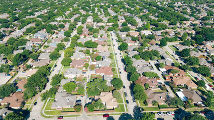 Parallel tree lined residential streets with row of large single-family houses, fenced backyard,...