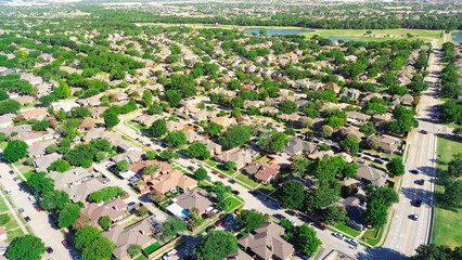 Lakeside residential neighborhood in Coppell suburbs Dallas, Texas, tree lined residential street, row of single-family houses fenced backyard, swimming pool, fast growing housing market, aerial