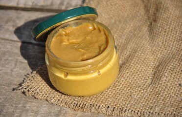 open glass jar with mustard on the table