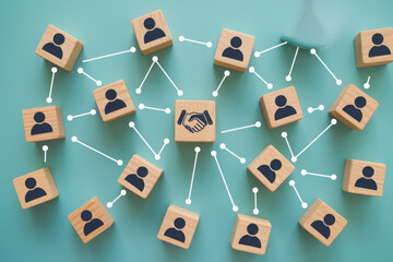 Hand shaking icon print screen on wooden block cube and linkage with people icon for corporate and business deal agreement concept. 
