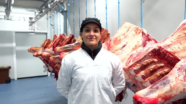 Portrait of a woman worker standing proud in the cold storage room of a meat factory