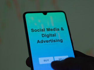 Social media & digital advertising etf fund on a screen. A phone shows the prices of Social Media & Digital Advertising