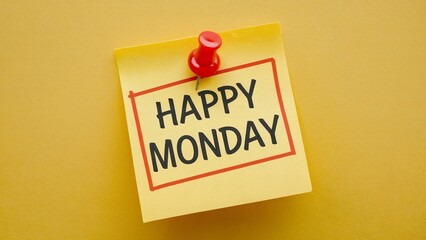 A yellow sticky note with the text Happy Monday and a red thumbtack