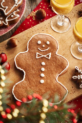 Man shaped gingerbread Christmas cookie with two glasses of Eiecognac on a table