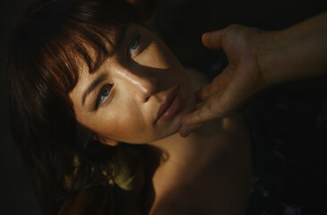 Tender moment as light casts shadows on a woman's face