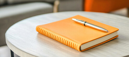 Orange notebook and pen sitting on modern living room table