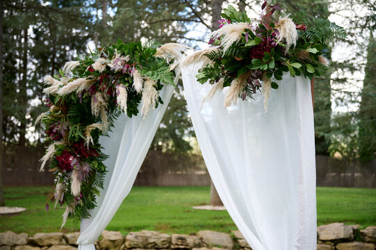 Elegant outdoor wedding arch with lush floral arrangement