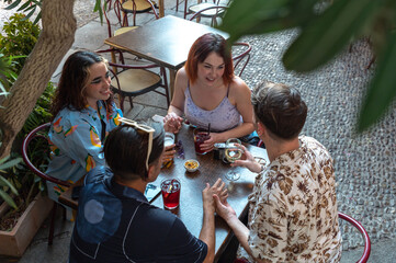 Group of friends enjoying drinks and conversation at an outdoor cafe