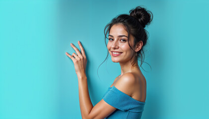 Obraz premium Smiling Young Woman Posing Against a Vibrant Blue Background