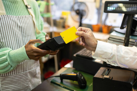 Customer making contactless payment at a garden store register