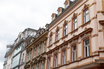 A picturesque row of various buildings featuring architecture against a backdrop of a cloudy sky that adds a dramatic touch to the scene