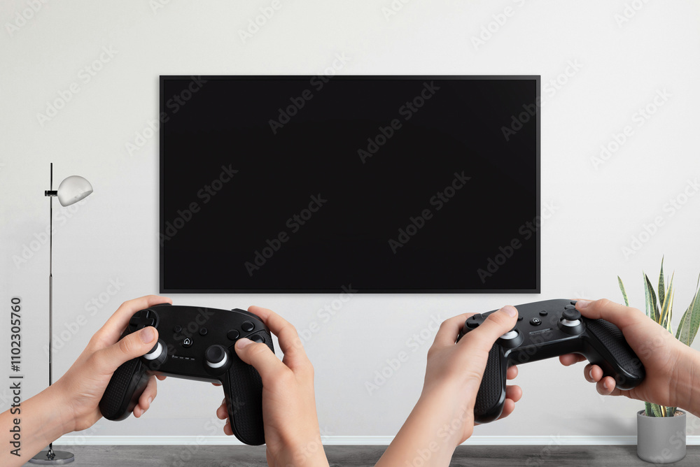Poster Two players holding gamepad in front of a TV with a blank screen, designed for video game promotion and mockup presentations