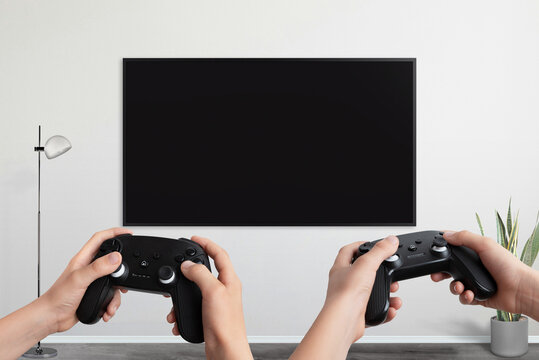 Two players holding gamepad in front of a TV with a blank screen, designed for video game promotion and mockup presentations
