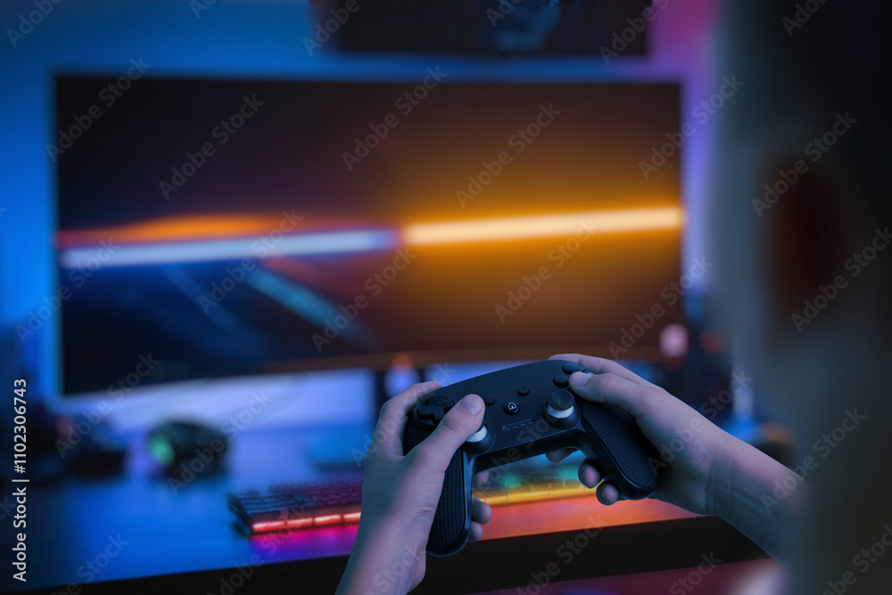 Poster player holding a gamepad in front of a large wide monitor with led lights, showcasing a pc gaming co