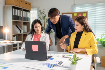 Asian business team working and brainstorming with data on tablet in office meeting