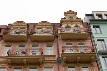 There is a row of wellconstructed buildings that feature balconies situated on their upper levels, creating an inviting urban atmosphere
