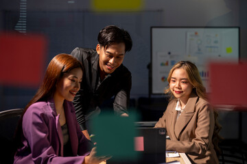 Young business people having meeting and working late using digital tablet in office at night