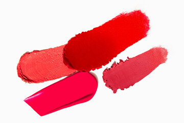 Range of red lipstick texture composition on a light white background. Cosmetic product smear smudge swatch sample.