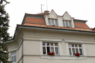 In the center of a picturesque setting stands a large, striking white building adorned with a classic red tile roof that enhances its charm