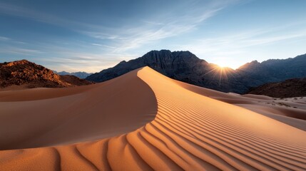 A stunning desert landscape featuring golden sand dunes illuminated by the setting sun against a backdrop of rugged mountains, creating a serene and majestic scene.