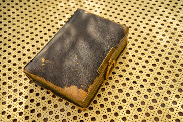 A miniature vintage photo album on a vintage armchair.Vintage photo album with scuffs from time.
