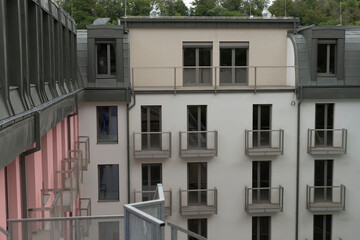 A modern residential building that features numerous large windows and multiple balconies for open views and outdoor space enjoyment