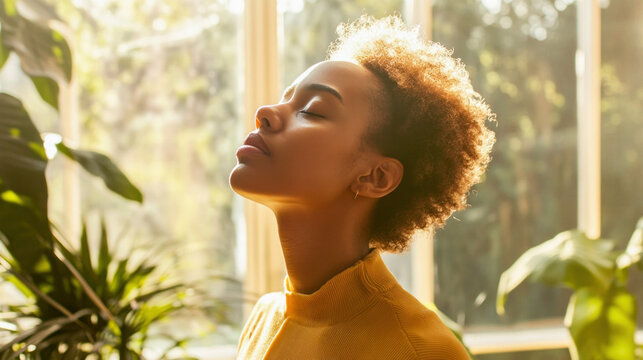 Young woman breathing fresh air and relaxing near window with plants