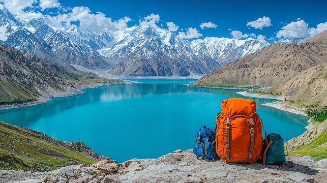 a bag pack set on a mountain ridge and lake Saif ul Maloo is visibal in the background some of the traveling equipment is set with the bagpack