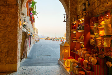 View through an arched doorway inside the covered bazaar of the city skyline and large public square at the Souq Waqif Bazaar Marketplace, in Doha, Qatar. © Kirk Fisher