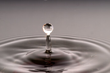 High-Speed Water Drop Collision: Artistic Liquid Splash with Reflective Details and Dark Background