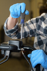 A technician repairs a device using a screwdriver in a workshop setting
