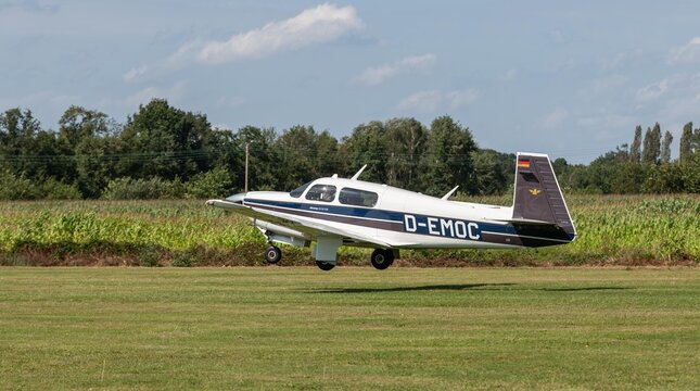 24 august 2024. A light airplane with propeller, type Mooney M20J 205 during take off at Kiewit regional airport. Open house at aero kiewit. Propeller airplane with number D-EMOC.