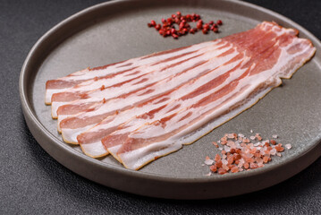 Fresh raw bacon sliced with spices and herbs