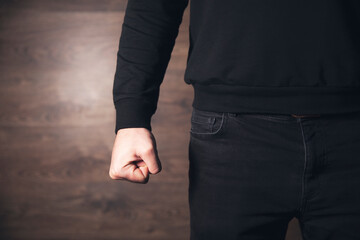 angry man fist on black wall background