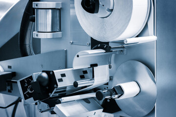 Fragment of the conveyor of sticking labeling machine. Abstract industrial background.