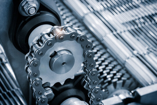 Gear chain drive shaft in conveyor belt is on production line. Timing chain of car, tensioners in engine. Industrial roller chain, technology. Team work, business industrial concept