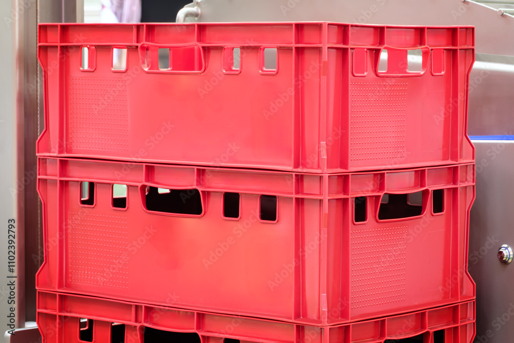 Poster two red plastic boxes stacked on top of each other. the boxes are empty