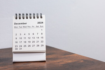 Minimalistic photo of a desk calendar showing December 2024. Clean and professional design, perfect for themes related to time management, planning, or organization.