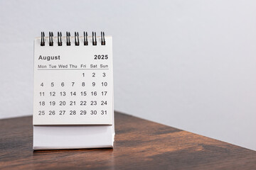 Minimalistic photo of a desk calendar showing August 2025. Clean and professional design, perfect for themes related to time management, planning, or organization.