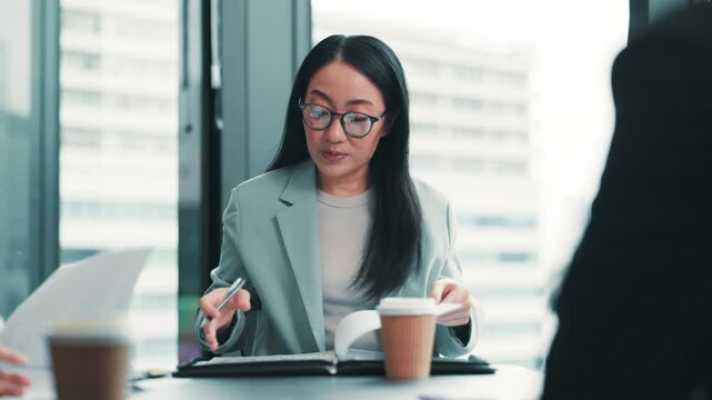 Japanese woman, paperwork and discussion for business strategy, brainstorming and progress update. Collaboration, planning project and leader in team meeting, program manager and feedback in office