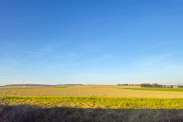 Autumn landscape in the countryside. Agricultural field and blue sky.