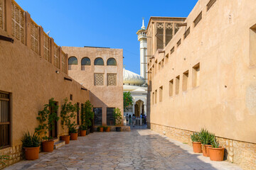 Alley view looking towards the wind tower and minaret in the Al Bastakiya Al Fahidi Cultural and Historical District, near Dubai Creek in Dubai, United Arab Emirates.	
