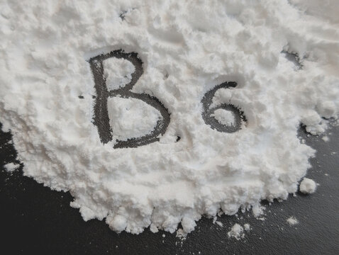 White powder on a black background. Letters B6. Vitamin B6. Bio hacking concept. Copy space