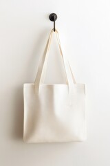 Stylish beige tote bag hanging on a minimalist hook, perfect for everyday use.