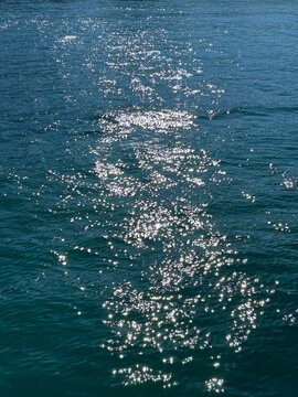 Blue ocean water with glittering sun reflections on surface