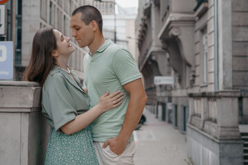 Happy couple of tourists walking embraced while sightseeing the town. Happy couple in front of palace of culture and science in Warsaw, Poland. Close up of a couple kissing.