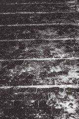 Snow-covered paving stones with textured surfaces, visible lines, and faint anti-slip protrusions. Winter evening outdoor scene in a park. Urban cold atmosphere.  
