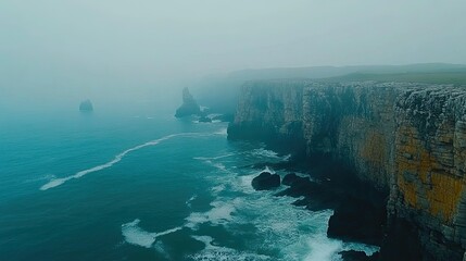 Misty coastal cliffs with dramatic ocean waves crashing against rocky shores.