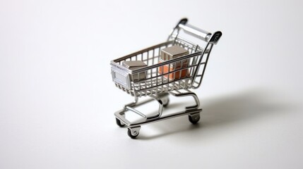 A miniature shopping cart with two small cardboard boxes inside, isolated on a white background.