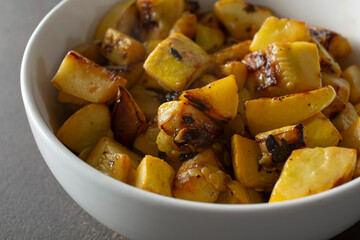 A closeup view of a bowl of sauteed yellow squash.
